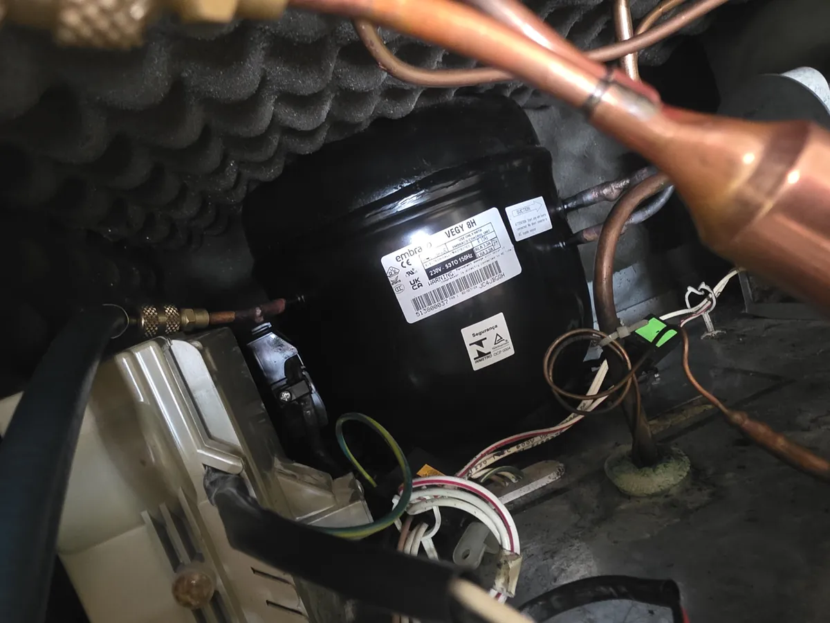 Compressor and sealed system at the back of a refrigerator