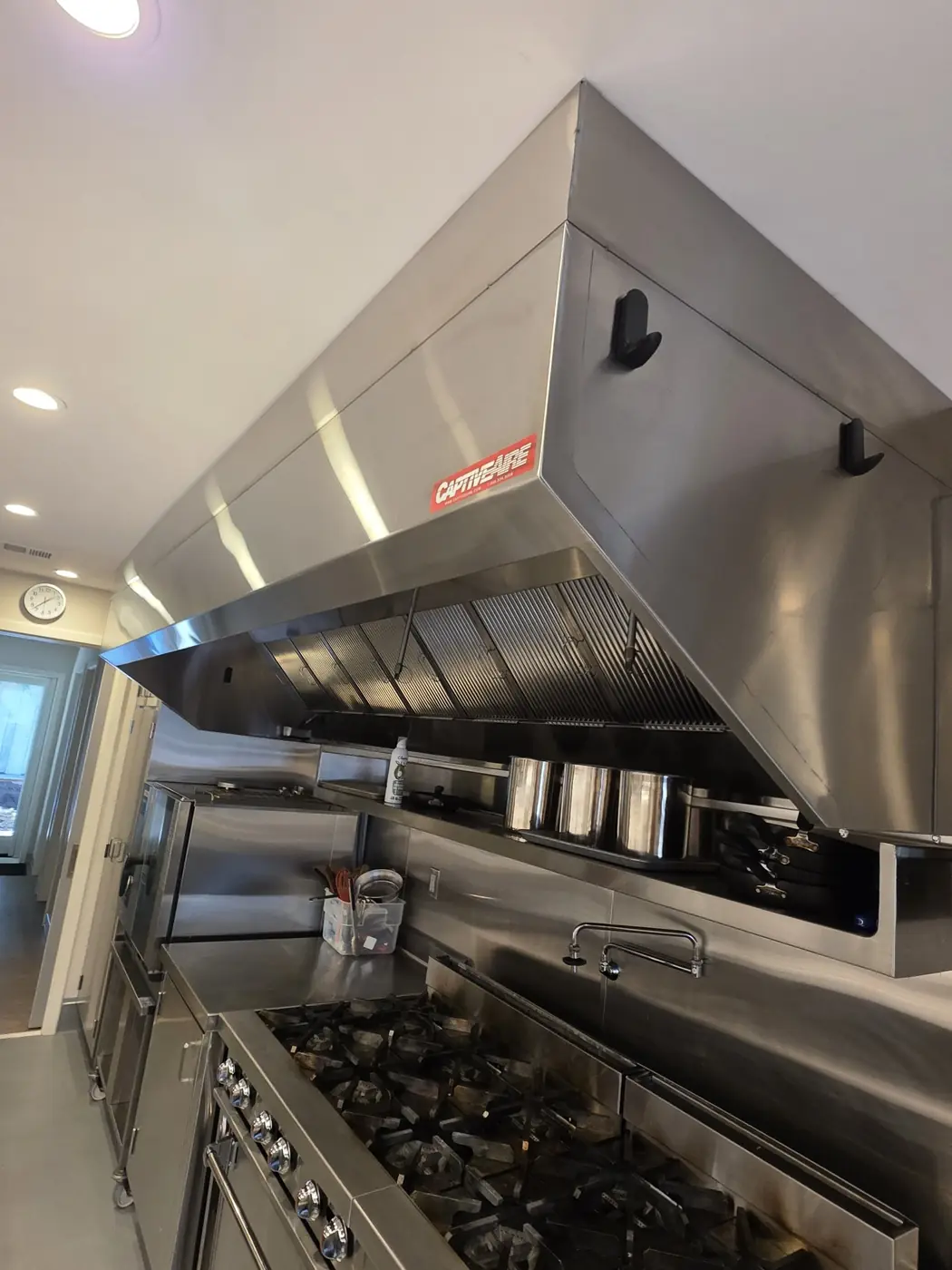 VOLT8 technician installing a commercial range hood in a Bay Area kitchen