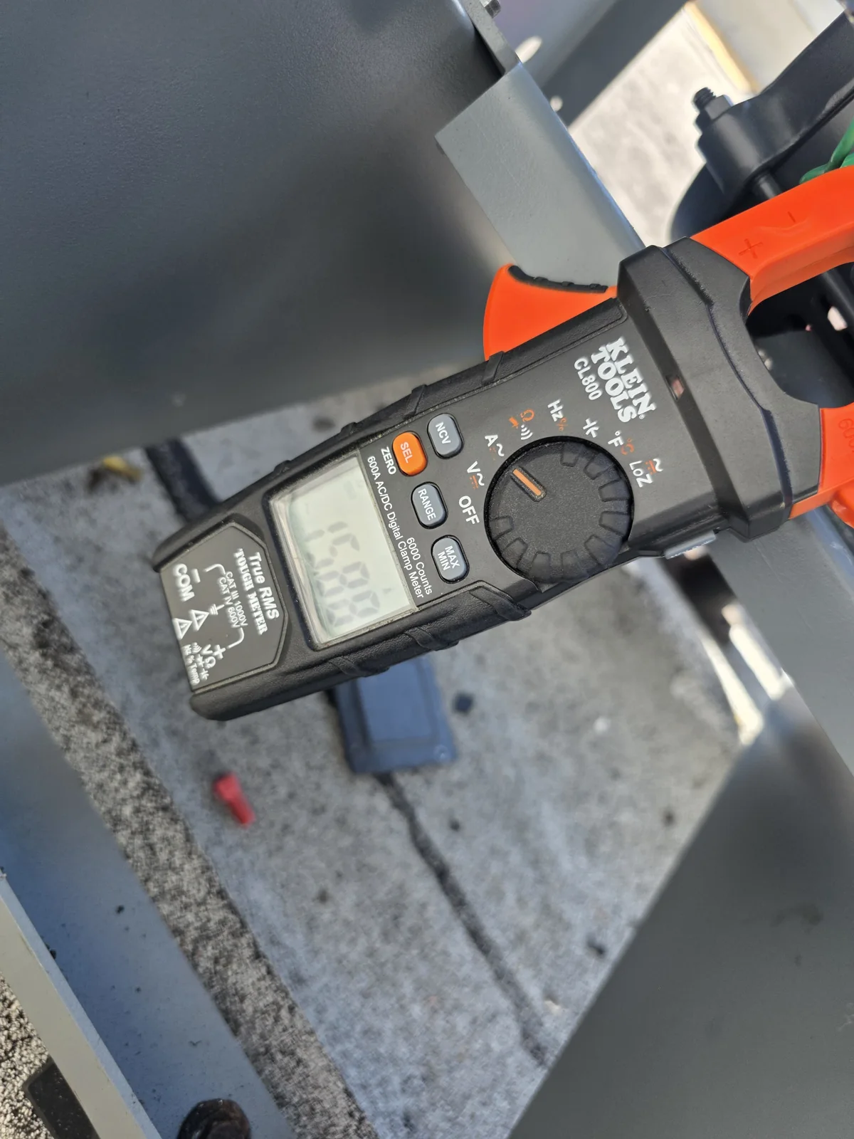 Clamp meter beside commercial kitchen rooftop exhaust assembly