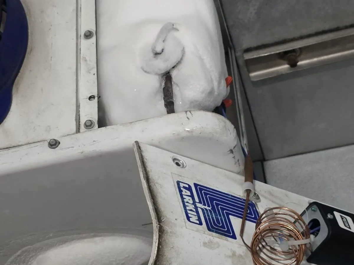 Ice built up across the evaporator coil inside a walk-in freezer