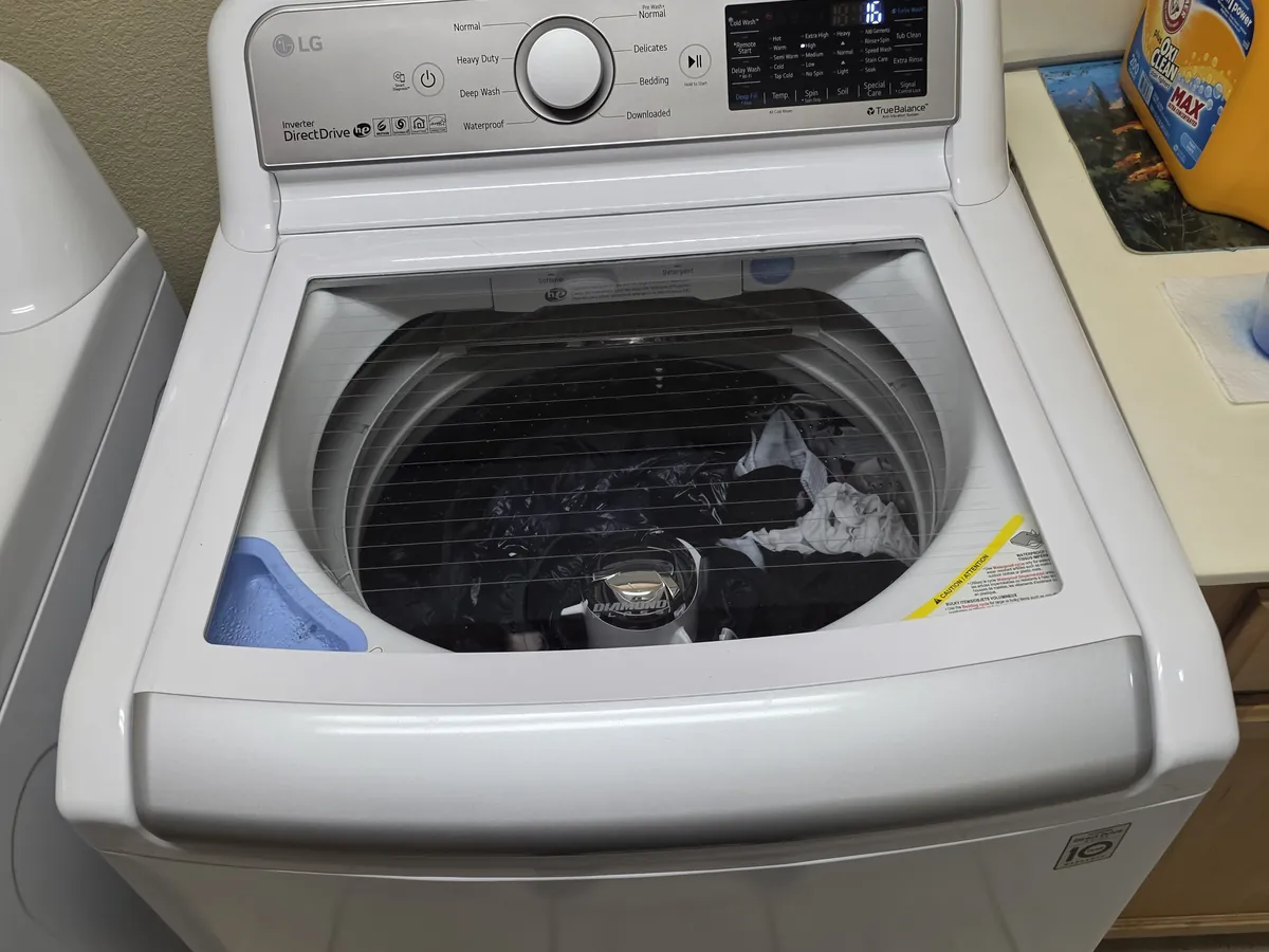 Top-load washing machine with the lid open in a Bay Area laundry room